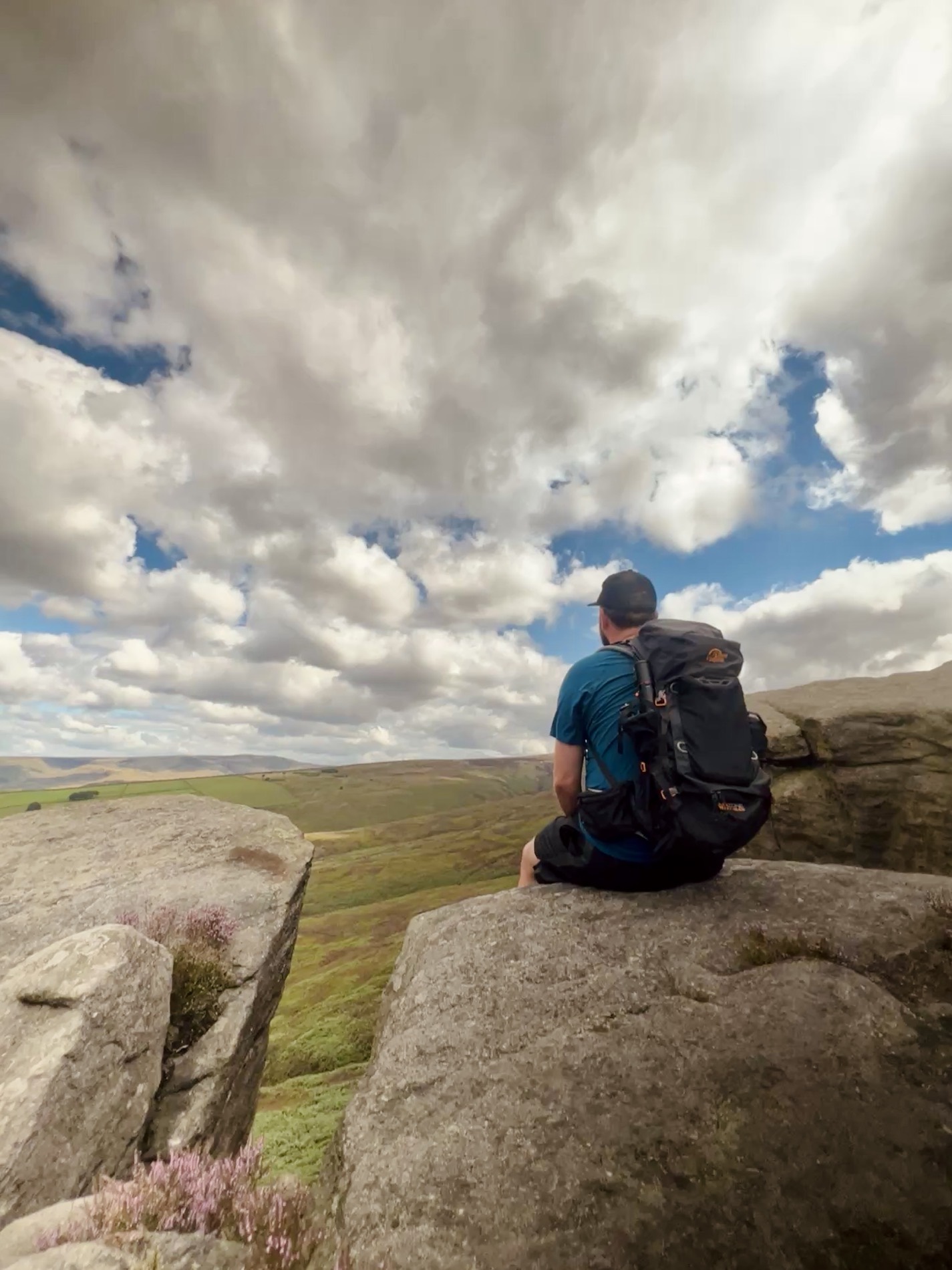 Matt Lacey sitting on a gritstone edge, looking out over the moors